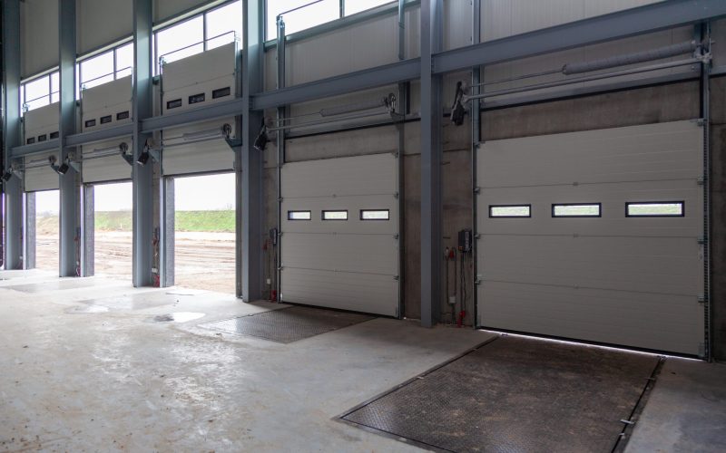 A row of loading bays in a warehouse with open and closed doors