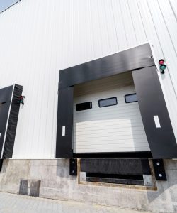 Sectional warehouse gate for loading and unloading cargo in a distributed center. Loading and unloading areas for trucks. Construction of an industrial building